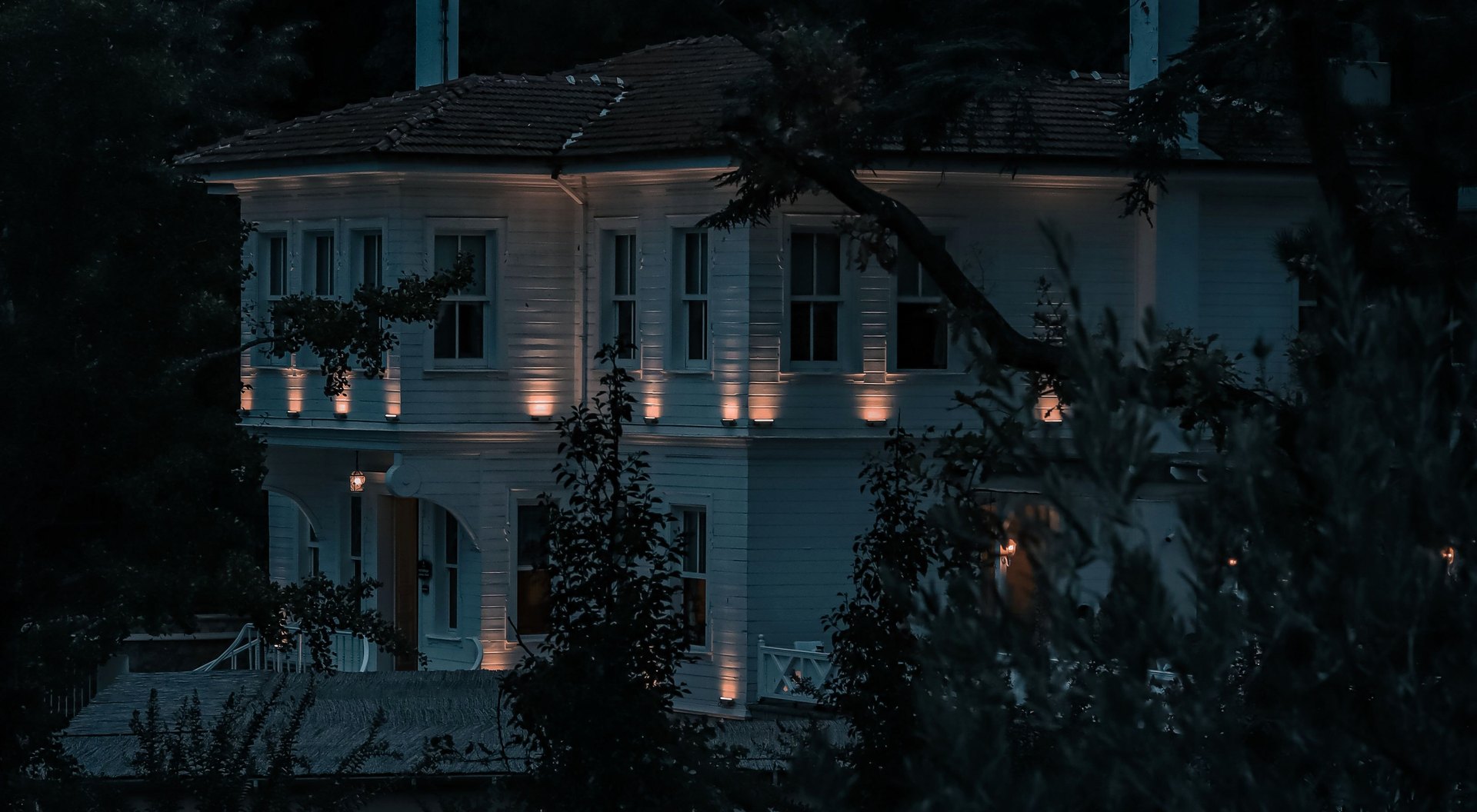 Residence facade at dusk, grazed by warm exterior up-lights