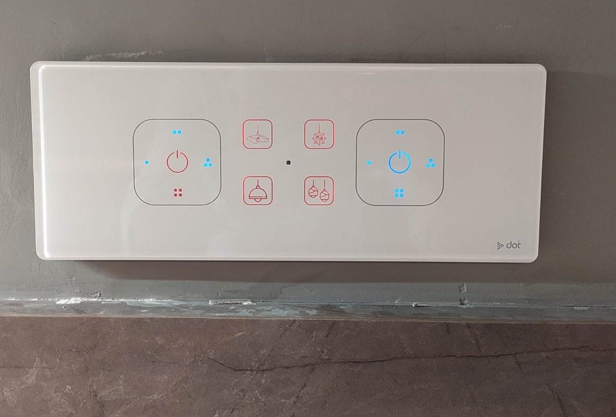 Live glass touch panel with dimmer rings on a grey wall
