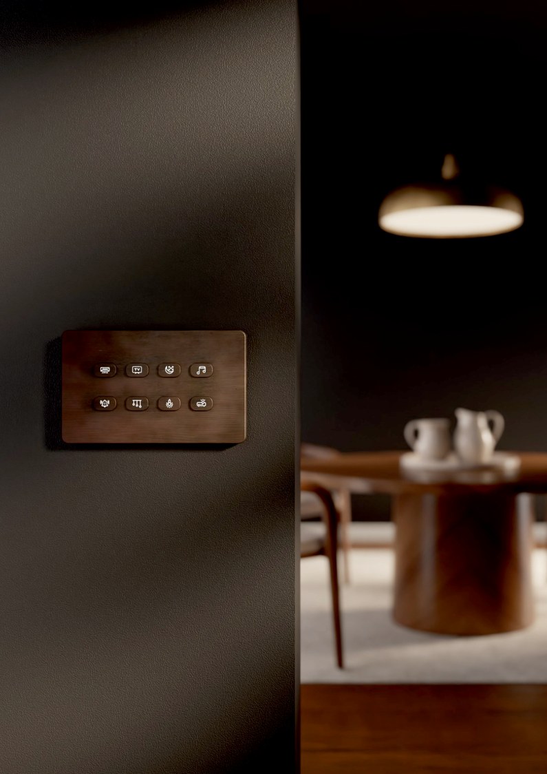 Bronze keypad on a dark wall, dining table lit behind